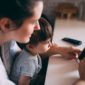 Madre e bambino che guardano insieme uno smartphone - privacy minori sui social